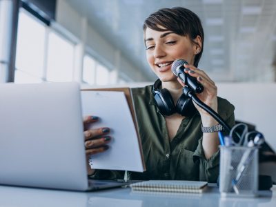 Young woman with microphone recording voice acting